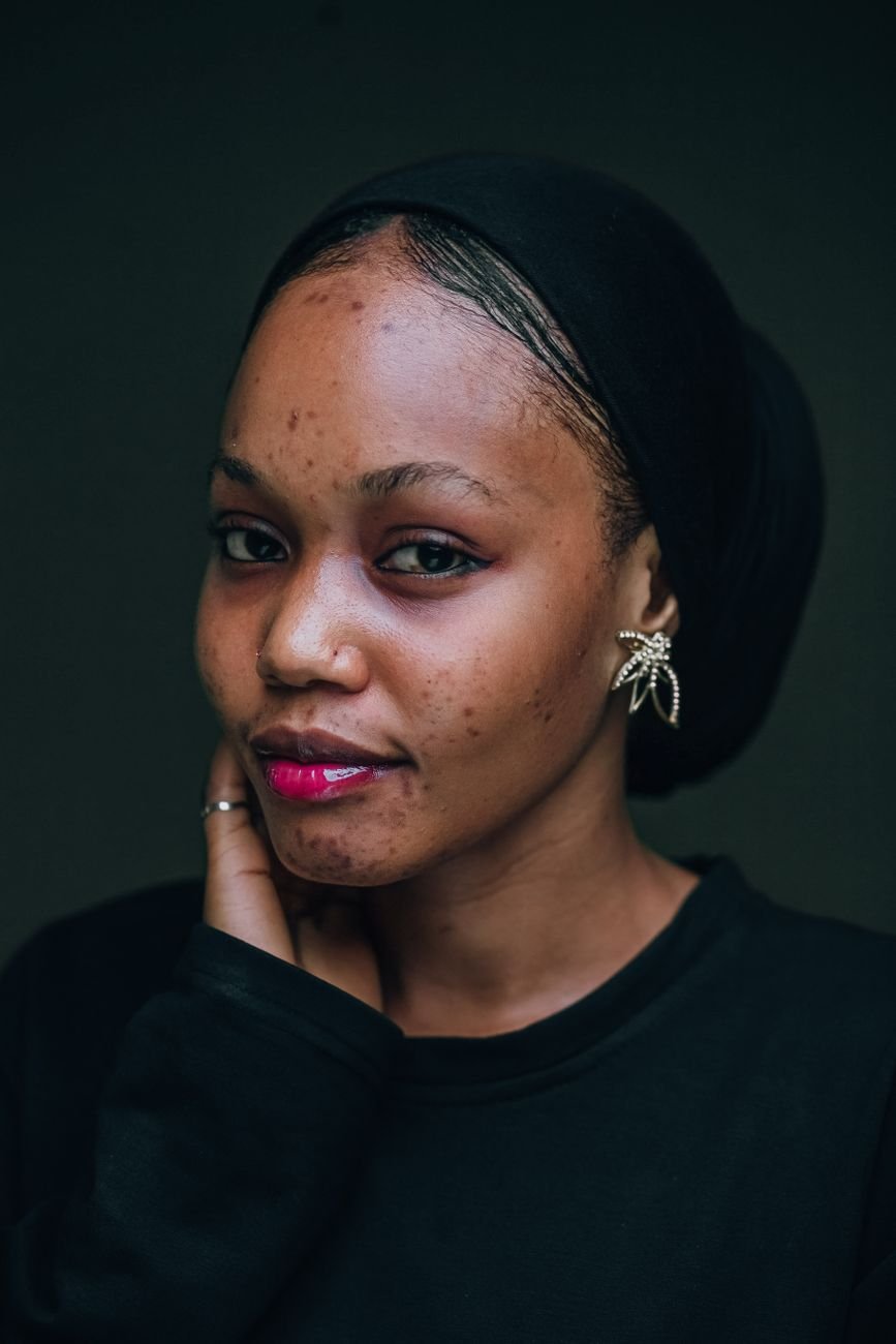 Close-up portrait of a Nigerian woman with a warm expression and elegant jewellery.